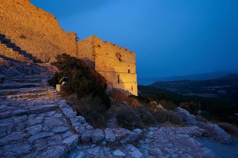 Night shot, Illuminated castle ruins on rocky terrain with a view of the surrounding landscape and