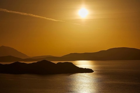 Golden sunset over calm sea with silhouetted archipelago, Makri Island, Alimia Island, Chalki