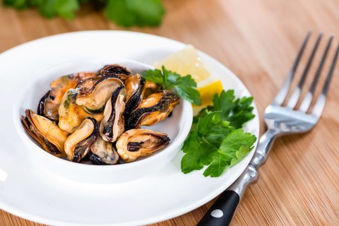 Pickled Mussels (with fresh herbs) as detailed close-up shot