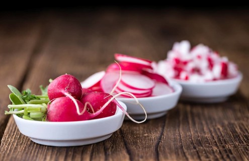Radishes (whole, sliced and diced) as detailed close-up shot (selective focus)