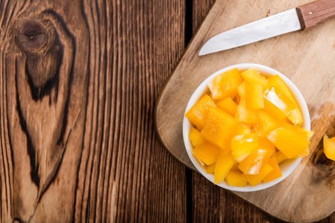 Sliced yellow Peppers (selective focus) on vintage wooden background
