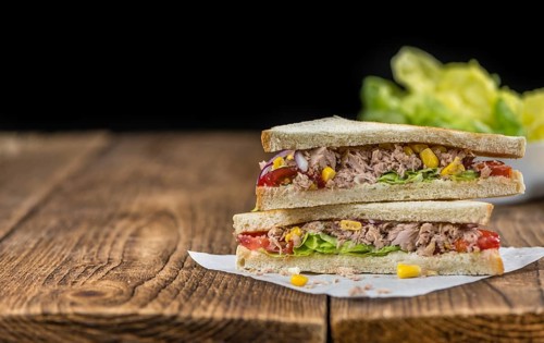 Wooden table with a fresh made Tuna Sandwich (selective focus, close-up shot)