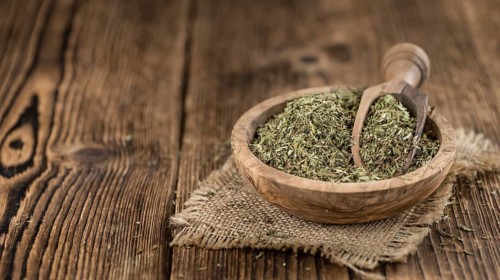 Portion of Stevia Leaves (dried, close-up shot) on wooden background