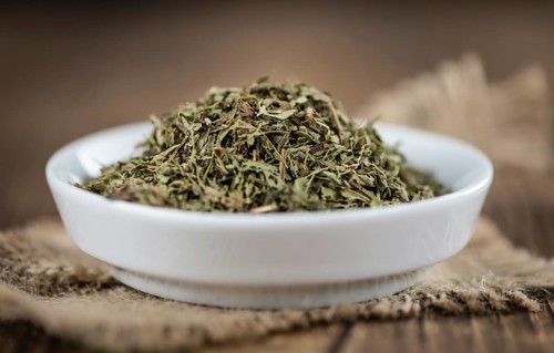 Heap of dried Stevia leaves (sweetener) on vintage background (close-up shot)