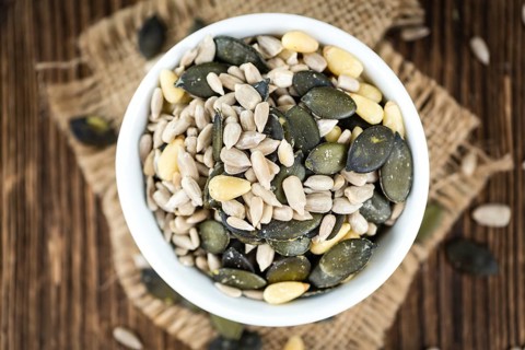 Old wooden table with mixed Seeds (close-up shot, selective focus)