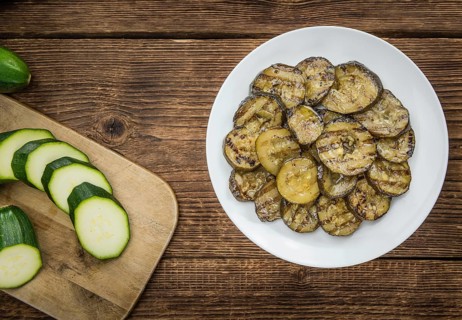 Zucchinis (grilled) as high detailed close-up shot on a vintage wooden table (selective focus)