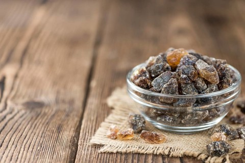 Wooden table with brown Rock Candy (close-up shot, selective focus)