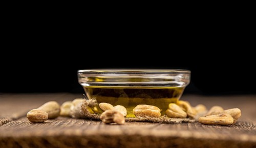 Fresh made Cashew Oil on an old wooden table (close-up shot, selective focus)