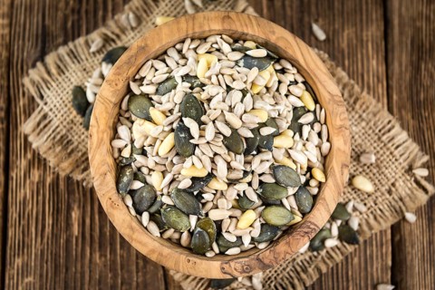 Old wooden table with mixed Seeds (close-up shot, selective focus)