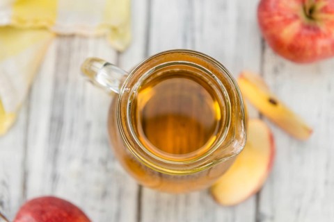 Apple Cider as high detailed close-up shot on a vintage wooden table (selective focus)