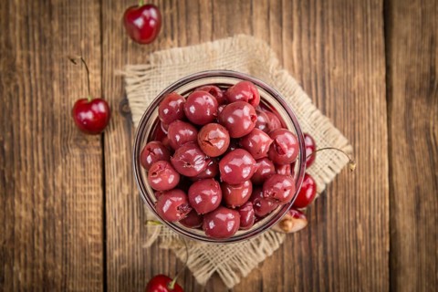Fresh made Canned Cherries on a vintage background as detailed close-up shot