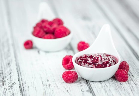Fresh made Raspberry Jam on an old and rustic wooden table, selective focus, close-up shot