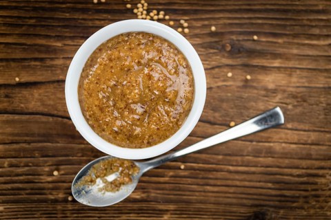 Fresh made German Cuisine (sweet Mustard) on a vintage background (close-up shot)