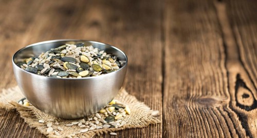 Old wooden table with mixed Seeds (close-up shot, selective focus)