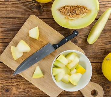 Fresh made Yellow Honeydew Melon on a vintage background (close-up shot)