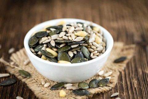 Old wooden table with mixed Seeds (close-up shot, selective focus)