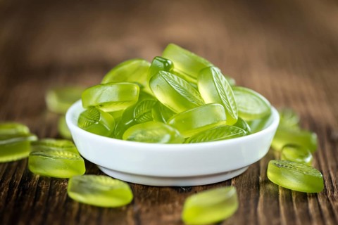 Lime candy (selective focus) on wooden background (close-up shot)