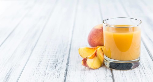 Peach juice (detailed close-up shot) on an old wooden table