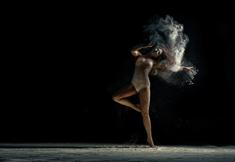 Amazing photo of graceful woman dancing with dust in studio