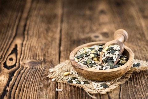 Old wooden table with mixed Seeds (close-up shot, selective focus)