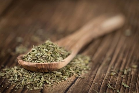 Portion of Stevia Leaves (dried, close-up shot) on wooden background