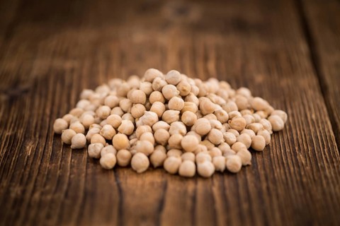 Dried Chickpeas as high detailed close-up shot on a vintage wooden table, selective focus