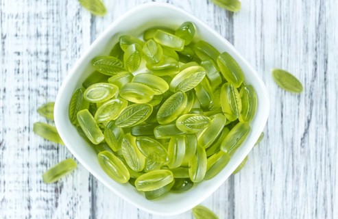 Lime candy (selective focus) on wooden background (close-up shot)