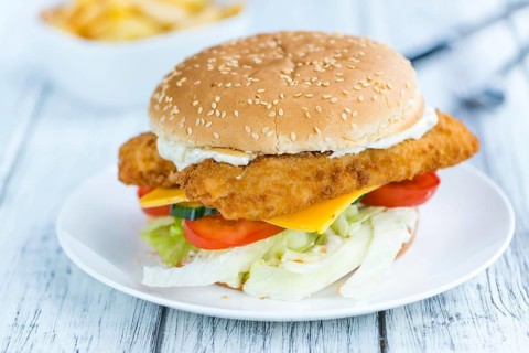 Fish Burger (selective focus, close-up shot) on wooden background