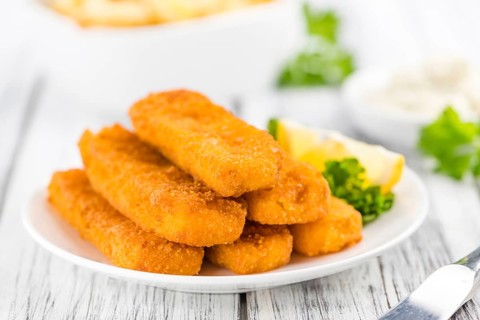 Fisch Sticks (close-up shot) on an old wooden table (selective focus)