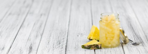 Preserved Pineapple pieces on a vintage background as detailed close-up shot, selective focus