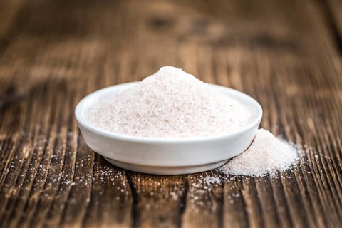 Pink Himalayan Salt on rustic wooden background (close-up shot)