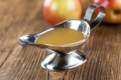Wooden table with Applesauce (close-up shot, selective focus)
