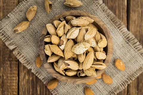 Almonds in shell (roasted and salted) on a vintage background (close-up shot)