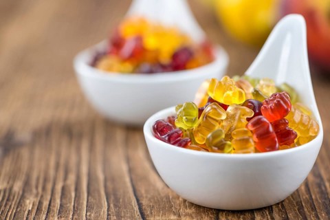 Wooden table with Gummy Bears (close-up shot, selective focus)