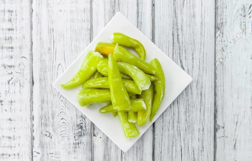 Fresh made Green Chilis (filled with cheese) on a vintage background (close-up shot)