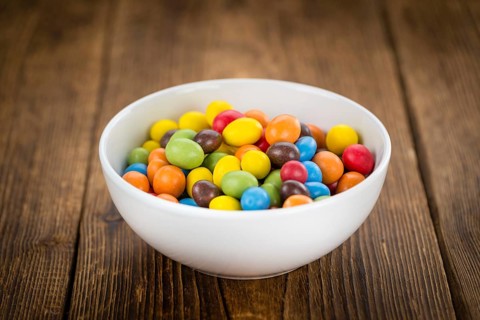 Fresh made Cocolate coated Peanuts on a vintage background (close-up shot)