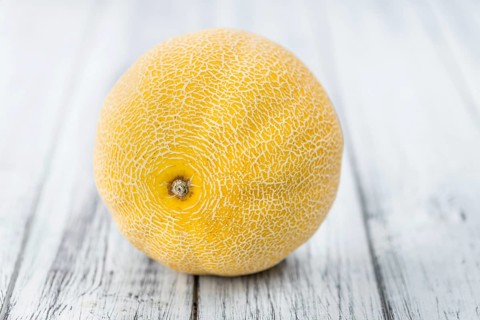 Honeydew Melon on an old wooden table as detailed close-up shot (selective focus)