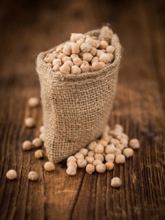 Chickpeas on an old wooden table as detailed close-up shot, selective focus