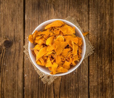 Sweet Potato Chips on an old wooden table as detailed close-up shot, selective focus