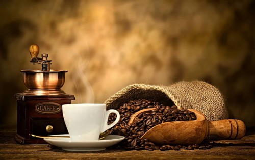 Cup of espresso coffee, coffee beans and old coffee grinder on the wooden table