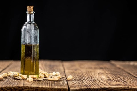 Fresh made Cashew Oil on an old wooden table (close-up shot, selective focus)