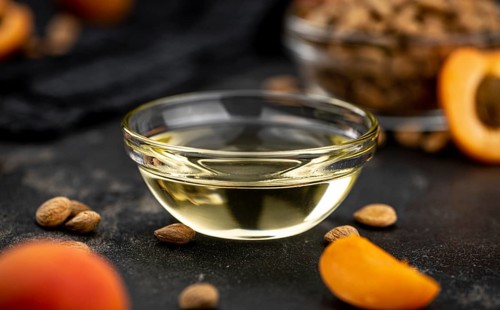 Portion of Apricot Oil with some fresh fruits as detailed close up shot (selective focus)