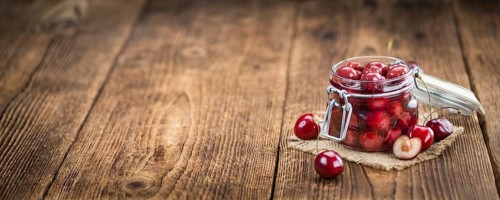 Fresh made Canned Cherries on a vintage background as detailed close-up shot