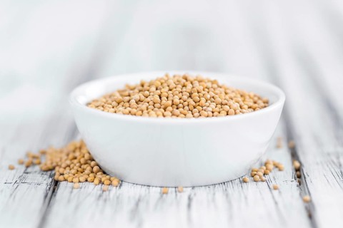 Seeds (Mustard) as high detailed close-up shot on a vintage wooden table (selective focus)