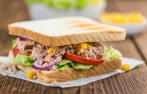 Homemade Tuna Sandwich (selective focus, close-up shot) on vintage wooden background