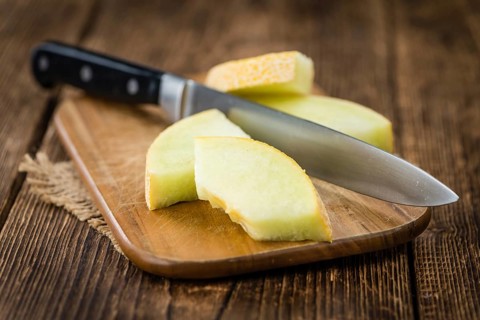 Honeydew Melon on an old wooden table as detailed close-up shot (selective focus)