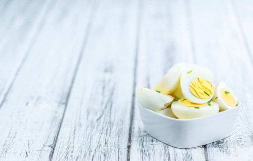 Wooden table with halved Eggs (selective focus, close-up shot)
