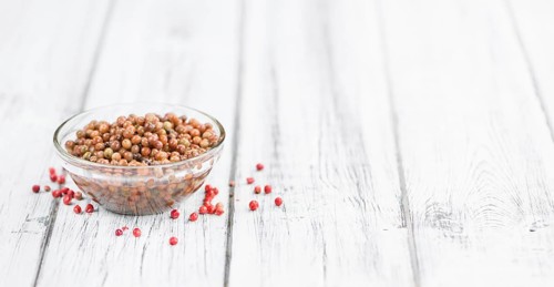 Preserved Pink Peppercorns on a vintage background as detailed close-up shot, selective focus