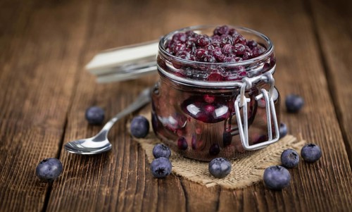 Homemade Preserved Blueberries on an wooden table as detailed close-up shot, selective focus