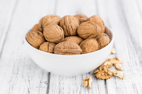 Walnuts on an old wooden table as detailed close-up shot (selective focus)